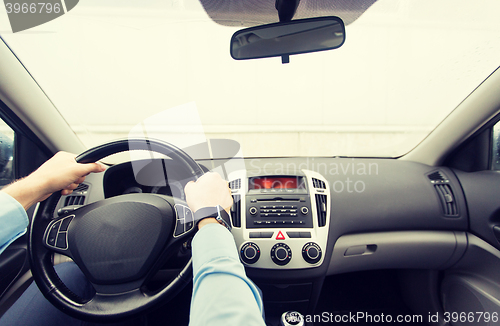 Image of close up of young man driving car