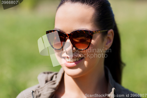 Image of face of happy young woman in sunglasses outdoors