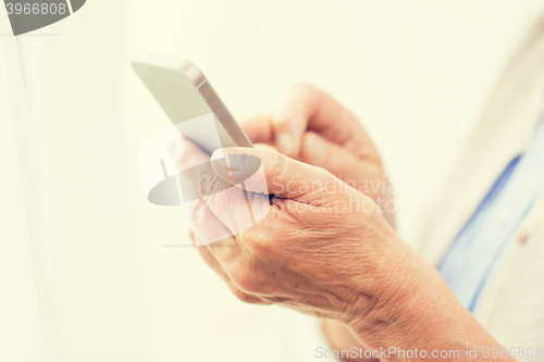 Image of close up of senior woman with smartphone texting