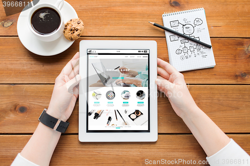 Image of close up of woman with tablet pc on wooden table