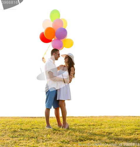 Image of smiling couple with air balloons outdoors