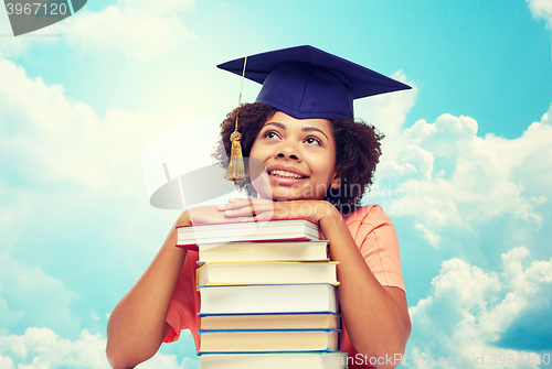 Image of happy african bachelor girl with books over sky