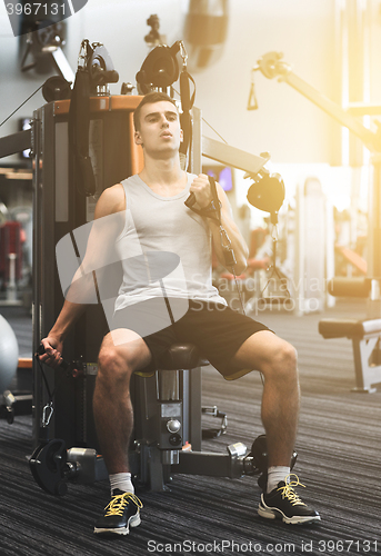 Image of man exercising on gym machine