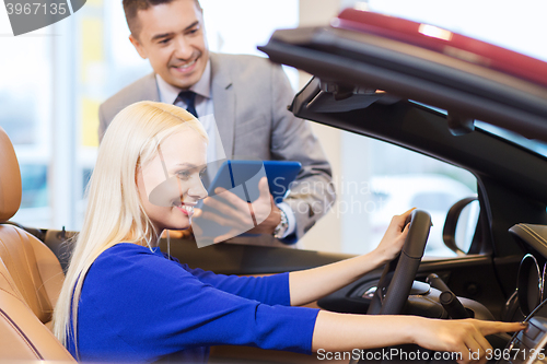 Image of happy woman with car dealer in auto show or salon