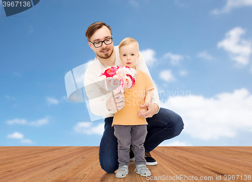 Image of happy father and son with bunch of flowers