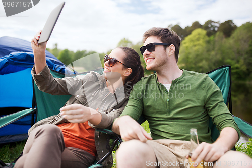 Image of happy couple with tablet pc at camping tent