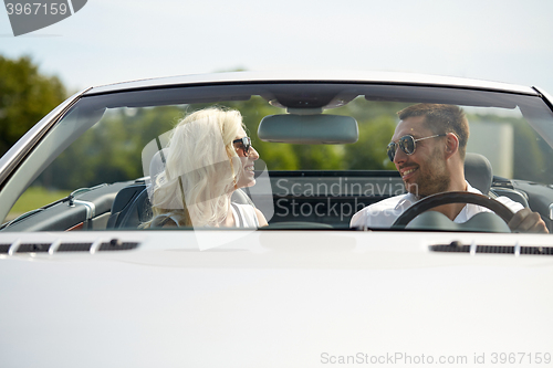 Image of happy man and woman driving in cabriolet car