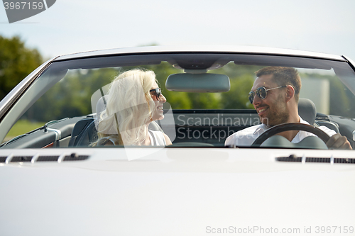 Image of happy man and woman driving in cabriolet car