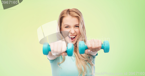 Image of smiling beautiful young sporty woman with dumbbell