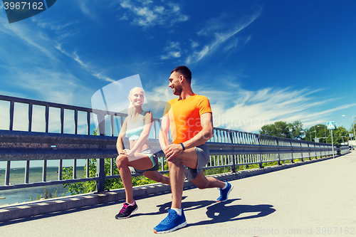 Image of smiling couple stretching outdoors