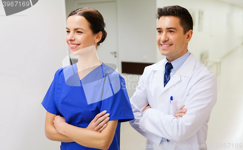 Image of smiling doctor in white coat and nurse at hospital