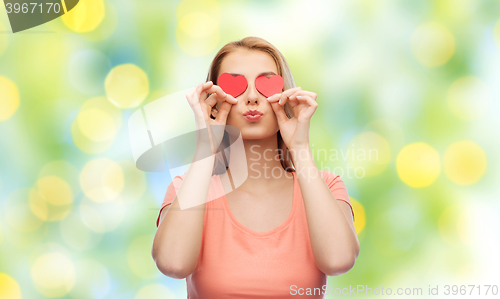 Image of happy young woman with red heart shapes on eyes