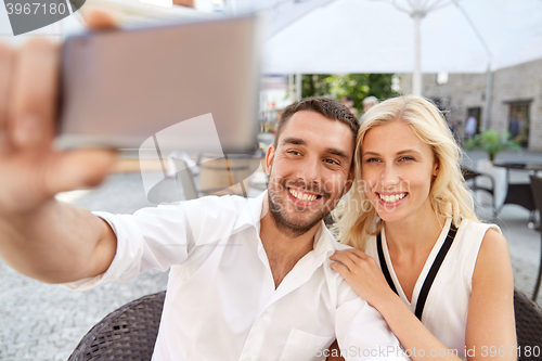 Image of couple taking selfie with smatphone at restaurant