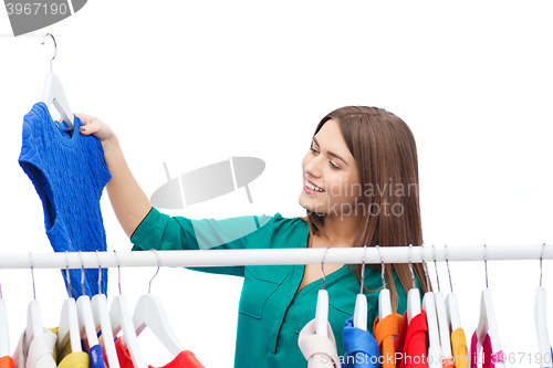 Image of happy woman choosing clothes at home wardrobe