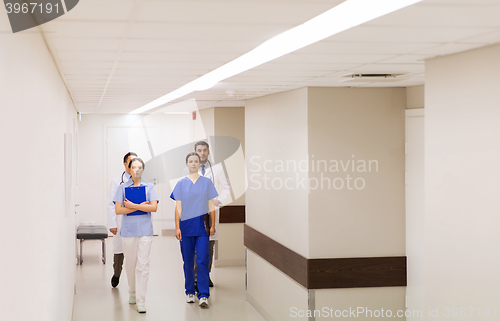 Image of group of medics or doctors walking along hospital