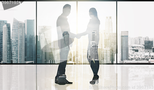 Image of business partners silhouettes making handshake