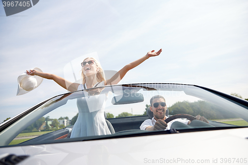 Image of happy man and woman driving in cabriolet car