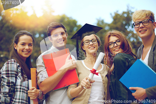Image of group of smiling students with diploma and folders