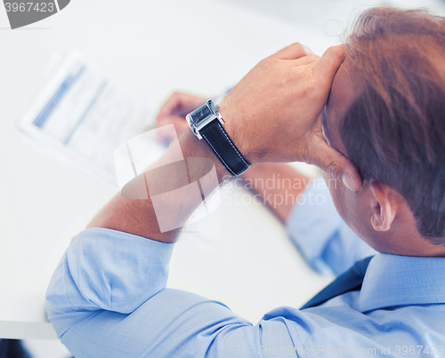 Image of stressed man filling tax form