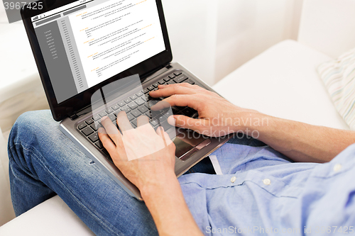 Image of close up of man typing on laptop computer at home