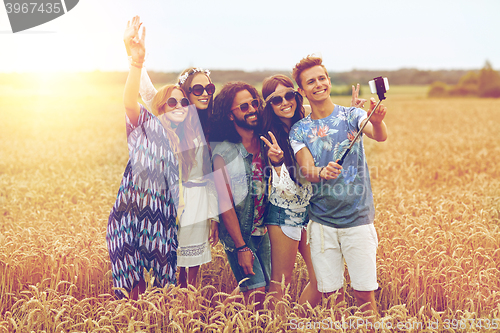 Image of hippie friends with smartphone on selfie stick