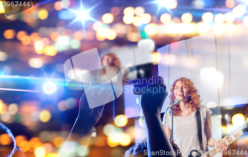 Image of hands with tablet pc taking video of music concert