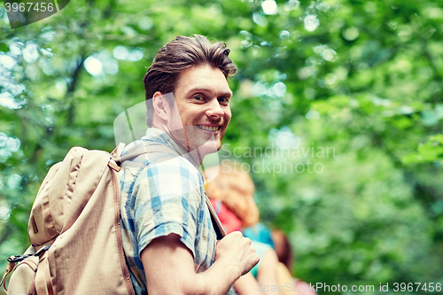 Image of group of smiling friends with backpacks hiking