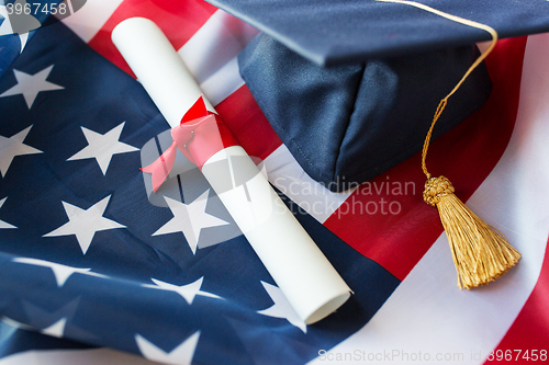 Image of mortarboard and diploma on american flag