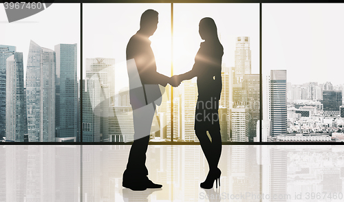 Image of business partners silhouettes making handshake