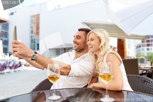 Image of happy couple taking selfie with tablet pc at cafe