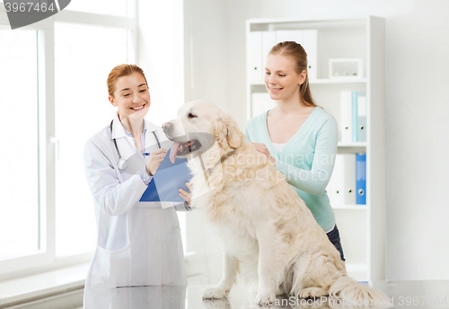 Image of happy doctor with retriever dog at vet clinic