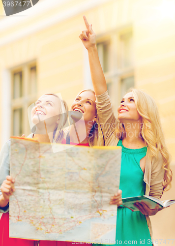 Image of beautiful women with tourist map in the city