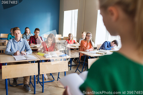 Image of group of students and girl with notebook at school