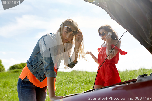 Image of women with open hood of broken car at countryside