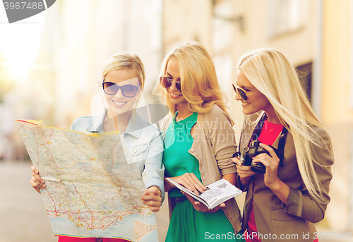 Image of beautiful women with tourist map in the city