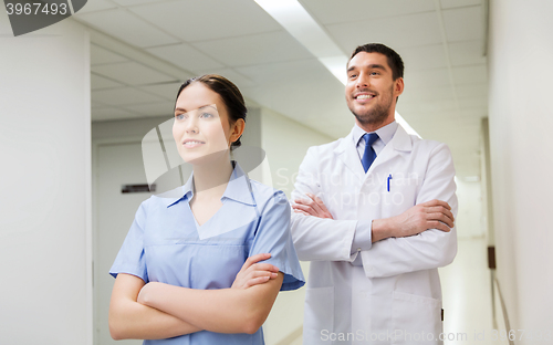 Image of smiling doctor in white coat and nurse at hospital