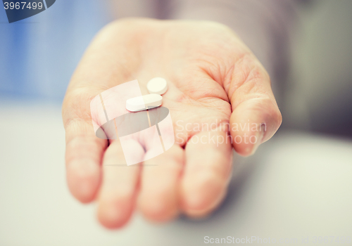 Image of close up of senior woman hand with pills