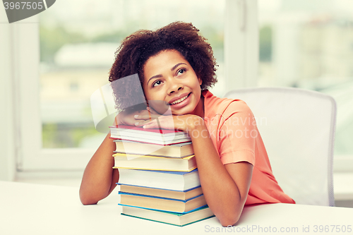 Image of happy african student girl with books at home