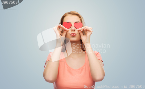 Image of happy young woman with red heart shapes on eyes