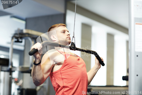 Image of man flexing muscles on cable machine gym