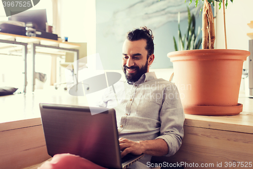 Image of happy creative male office worker with laptop