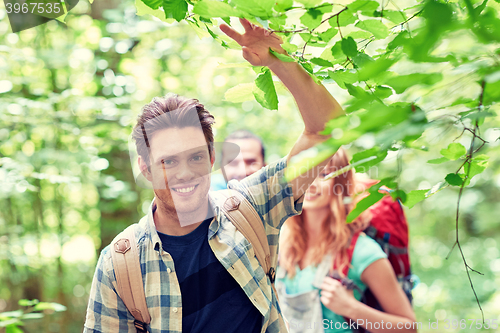 Image of group of smiling friends with backpacks hiking