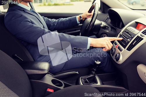 Image of close up of young man in suit driving car