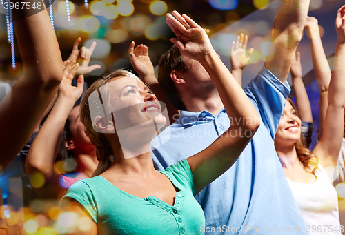 Image of smiling friends at concert in club