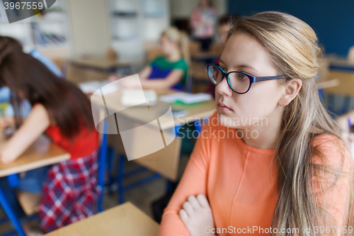 Image of student girl in eyeglasses at school lesson