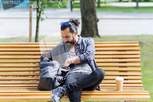 Image of man with backpack and earphones in city