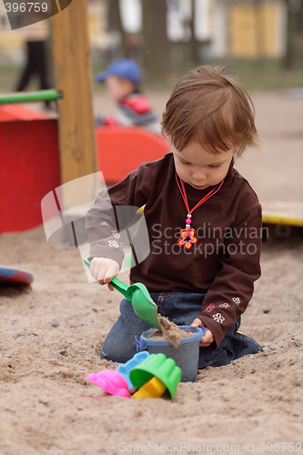 Image of little girl playing at sand-box