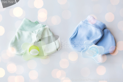 Image of close up of baby mittens and soothers for twins