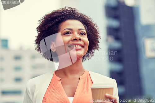 Image of happy african businesswoman with coffee in city