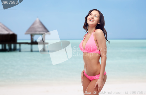 Image of happy young woman in pink bikini swimsuit